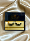 Icon strip lashes in open black and gold Winked Rose box on satin fabric