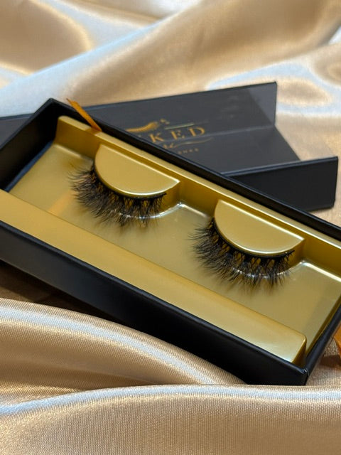 Tempted strip lashes in open black and gold Winked x Kari box on champagne satin fabric